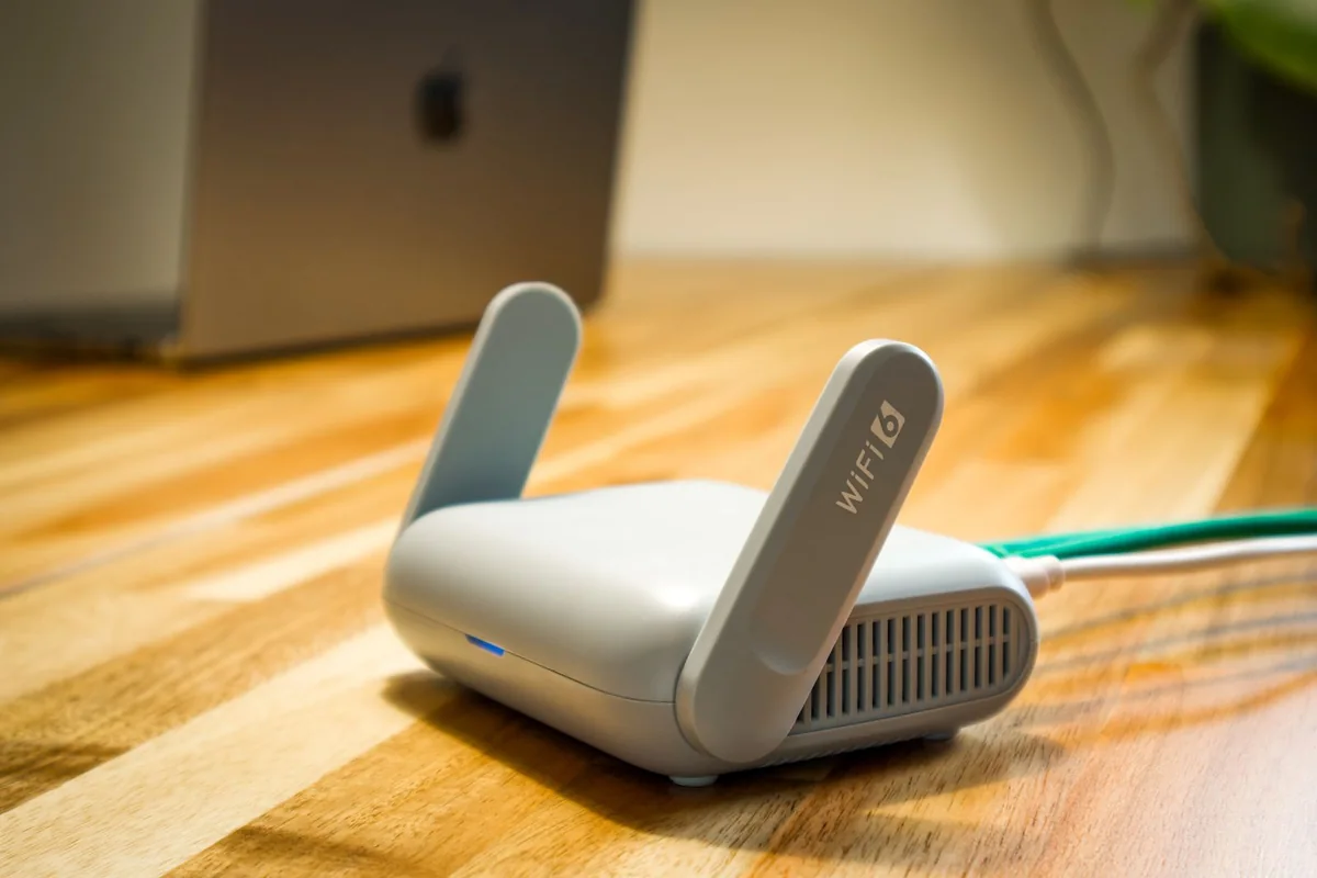 Wi-Fi router and cable on a wooden desk.