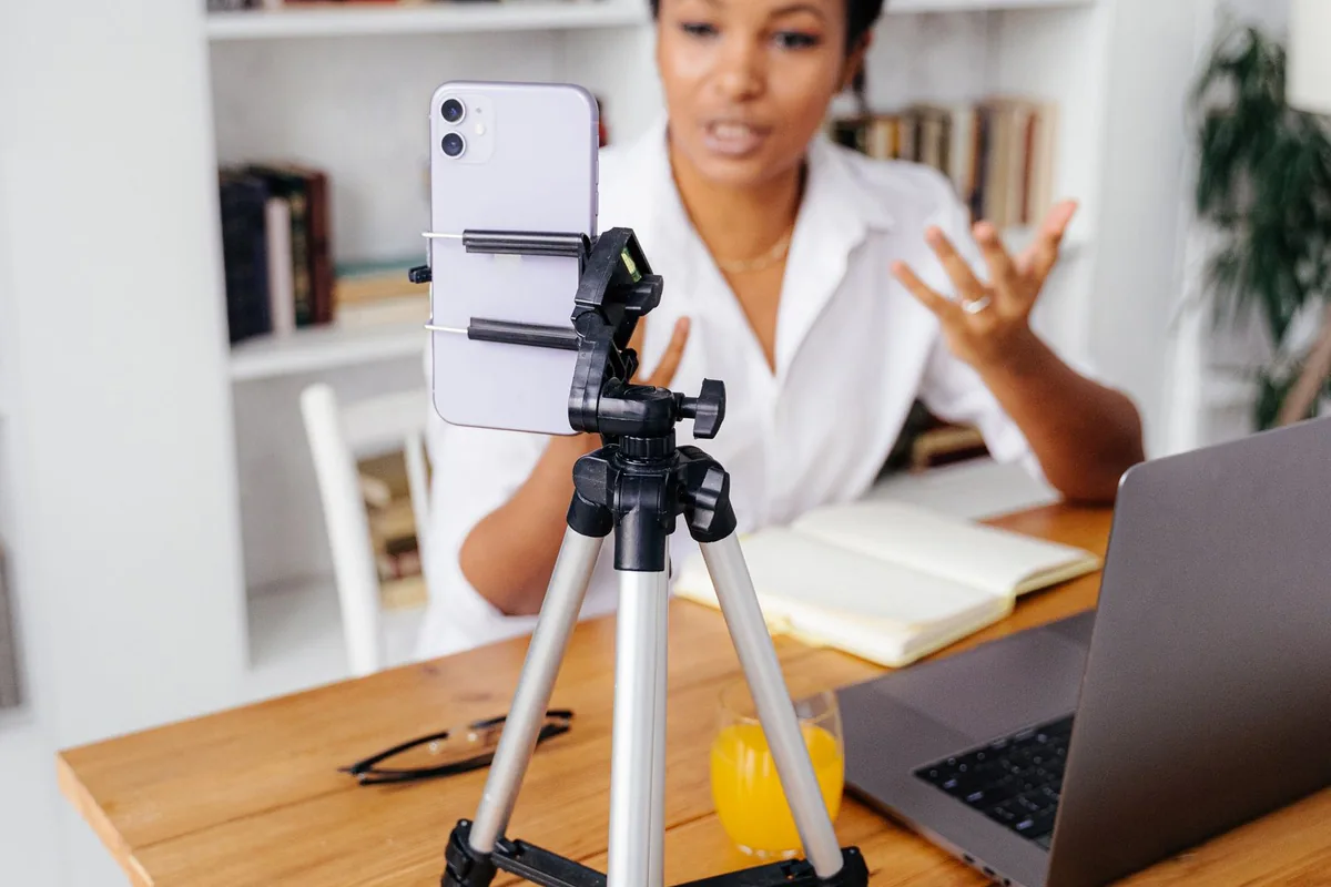 Phone on a tripod used for recording at a home-office desk.